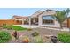 A beautiful backyard with travertine patio, desert landscaping, green space, and covered seating area at 25920 W Westcott Dr, Buckeye, AZ 85396