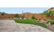 Beautifully landscaped backyard with artificial turf, desert plants, rocks, and a travertine patio at 25920 W Westcott Dr, Buckeye, AZ 85396