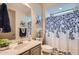 Well-lit bathroom with a floral shower curtain and elegant fixtures at 25920 W Westcott Dr, Buckeye, AZ 85396