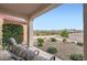 Relaxing covered patio with desert views, comfortable seating, and charming landscaping at 25920 W Westcott Dr, Buckeye, AZ 85396