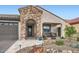 Charming home featuring desert landscaping, stone accents, and a welcoming covered porch at 25920 W Westcott Dr, Buckeye, AZ 85396