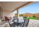 Inviting covered patio area with a stone floor, outdoor furniture, and views of the landscaped backyard at 25920 W Westcott Dr, Buckeye, AZ 85396