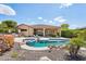 Stunning backyard with a sparkling pool, spa, lush landscaping, and an outdoor kitchen at 27688 N 125Th Dr, Peoria, AZ 85383