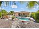 Lush backyard featuring a pool, spa, outdoor kitchen, and rock water feature at 27688 N 125Th Dr, Peoria, AZ 85383