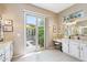 Bright bathroom with granite countertops, white cabinets, and sliding glass door to the outside patio at 27688 N 125Th Dr, Peoria, AZ 85383