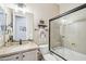 Bathroom featuring a glass-enclosed shower over tub, granite countertops, and vanity sink at 27688 N 125Th Dr, Peoria, AZ 85383