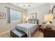 Well-lit bedroom with white shutters, a ceiling fan, and a comfortable reading chair at 27688 N 125Th Dr, Peoria, AZ 85383