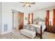 Attractive bedroom with a decorative bed frame, sliding barn door, hardwood floors and a ceiling fan at 27688 N 125Th Dr, Peoria, AZ 85383