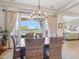 Bright dining room with a rustic table, stylish chandelier, and large windows at 27688 N 125Th Dr, Peoria, AZ 85383