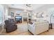 Cozy living room with fireplace, tile flooring, ceiling fan, and comfortable furniture at 27688 N 125Th Dr, Peoria, AZ 85383