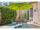 Private patio with a small dining set, an umbrella, and lush greenery at 27688 N 125Th Dr, Peoria, AZ 85383