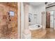 Spa-like bathroom featuring a separate shower, travertine tile, and soaking tub at 3675 N 59Th Pl, Phoenix, AZ 85018