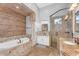 Bathroom with tub, vanity, walk-in shower and brick accent wall at 3675 N 59Th Pl, Phoenix, AZ 85018