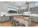 Well-lit kitchen boasts a large island, stainless steel range hood, and gray custom cabinetry at 3675 N 59Th Pl, Phoenix, AZ 85018