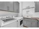 Well-equipped laundry room featuring a modern washer, dryer, ample cabinet space, and utility sink at 3675 N 59Th Pl, Phoenix, AZ 85018