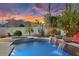 Backyard pool area with a waterfall feature, surrounded by lush greenery and comfortable lounge chairs at 3675 N 59Th Pl, Phoenix, AZ 85018