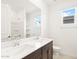 Bright bathroom featuring double sinks, dark wood vanity, and walk in shower at 37215 W Patterson St, Maricopa, AZ 85138