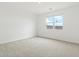 Bright bedroom with plush carpet and a large window with a view at 37215 W Patterson St, Maricopa, AZ 85138