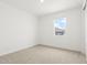 Bright bedroom with neutral carpet, white walls, and a window providing natural light at 37215 W Patterson St, Maricopa, AZ 85138