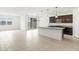 Open-concept living area with tile floors, dark cabinets, and sliding glass doors to the backyard at 37215 W Patterson St, Maricopa, AZ 85138