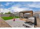 Spacious backyard with gazebo, outdoor furniture, lush synthetic grass, playground, grill, and pavers at 37384 W Prado St, Maricopa, AZ 85138