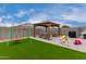 Entertaining backyard with synthetic grass, gazebo, outdoor furniture, grill, swing set, and toys at 37384 W Prado St, Maricopa, AZ 85138