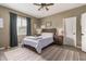 Cozy bedroom with a queen-size bed, ceiling fan, neutral walls, and natural light from the window at 37384 W Prado St, Maricopa, AZ 85138