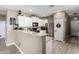 Modern kitchen features white cabinetry, granite countertops, stainless steel appliances, and tile flooring at 37384 W Prado St, Maricopa, AZ 85138