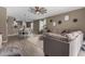 Open-concept living room featuring tile flooring, a ceiling fan, and comfortable seating with view of the kitchen at 37384 W Prado St, Maricopa, AZ 85138