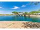 Community pond view with decorative fountains, trees, and a park under a blue sky at 37384 W Prado St, Maricopa, AZ 85138