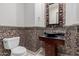 Stylish powder room with mosaic tile accent wall, vessel sink, and decorative mirror at 3816 E Expedition Way, Phoenix, AZ 85050