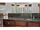 A close-up view of a dark granite countertop with a sink and cabinets at 3816 E Expedition Way, Phoenix, AZ 85050