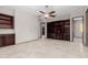 Bright living room featuring custom built-ins, tile flooring, and a modern ceiling fan at 3816 E Expedition Way, Phoenix, AZ 85050