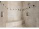 This shower features travertine tile, a built-in bench, and shower niche at 3816 E Expedition Way, Phoenix, AZ 85050