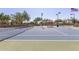 Outdoor tennis court with well-maintained surface, lighting, and a covered bench for relaxing between sets at 3816 E Expedition Way, Phoenix, AZ 85050