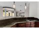 Dark wet bar featuring pendant lighting and sink with a view into the living room at 3816 E Expedition Way, Phoenix, AZ 85050