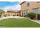 Backyard featuring synthetic grass, desert landscaping, and lush plants around the home's perimeter at 3940 E Geronimo St, Gilbert, AZ 85295