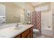 Well-lit bathroom features a large vanity, a decorative shower curtain, and a combination bathtub and shower at 3940 E Geronimo St, Gilbert, AZ 85295