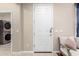 Clean, bright entryway featuring a white door, modern laundry machines and a comfortable seating area at 3940 E Geronimo St, Gilbert, AZ 85295
