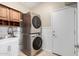Convenient laundry room features a stacked washer and dryer and a utility sink with wooden storage cabinets at 3940 E Geronimo St, Gilbert, AZ 85295