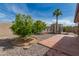 Spacious backyard featuring desert landscaping, a cozy patio, mature trees and a modern greenhouse at 4158 E Crescent Ave, Mesa, AZ 85206