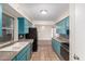 Galley-style kitchen featuring blue cabinets, black appliances, tile floors and granite countertops at 4158 E Crescent Ave, Mesa, AZ 85206