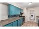 Well-lit kitchen featuring blue cabinets, stainless steel appliances and a laundry area view at 4158 E Crescent Ave, Mesa, AZ 85206