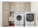 Bright laundry room with washer, dryer, sink, and cabinets at 4158 E Crescent Ave, Mesa, AZ 85206
