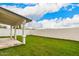 Spacious backyard with lush grass and a covered patio with palm tree and white fence at 4319 E Contessa St, Mesa, AZ 85205