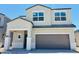 Two-story home featuring a two-car garage, covered porch, and a modern design with neutral stucco and tile roof at 5075 E Umber Rd, San Tan Valley, AZ 85143