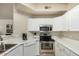 Compact kitchen featuring white cabinetry, stainless steel appliances, and light countertops at 5303 N 7Th St # 118, Phoenix, AZ 85014
