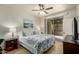 Comfortable main bedroom with ceiling fan, art and access to patio at 5303 N 7Th St # 118, Phoenix, AZ 85014