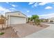 Single-story home with two-car garage featuring a brick driveway and desert landscaping at 5312 W Hardtack Trl, Laveen, AZ 85339