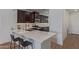A modern kitchen with dark cabinets, stainless steel appliances, and a quartz countertop island with seating at 5312 W Hardtack Trl, Laveen, AZ 85339